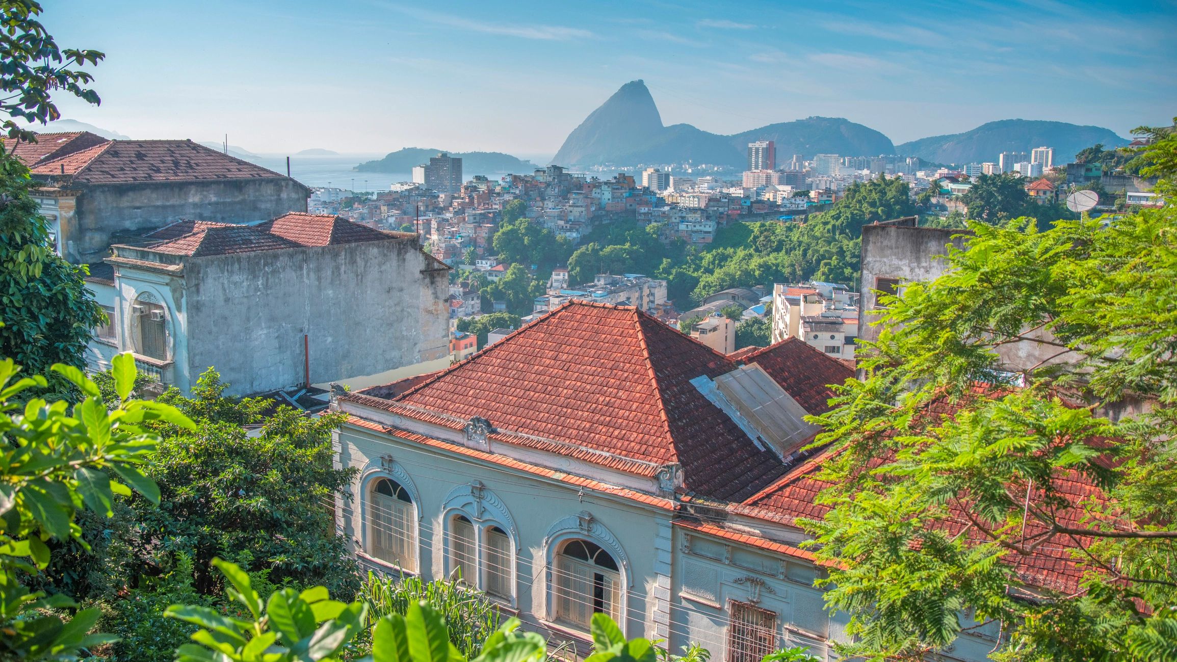 Editorial view over Rio de Janeiro with Sugarloaf Mountain and tropical hillside architecture