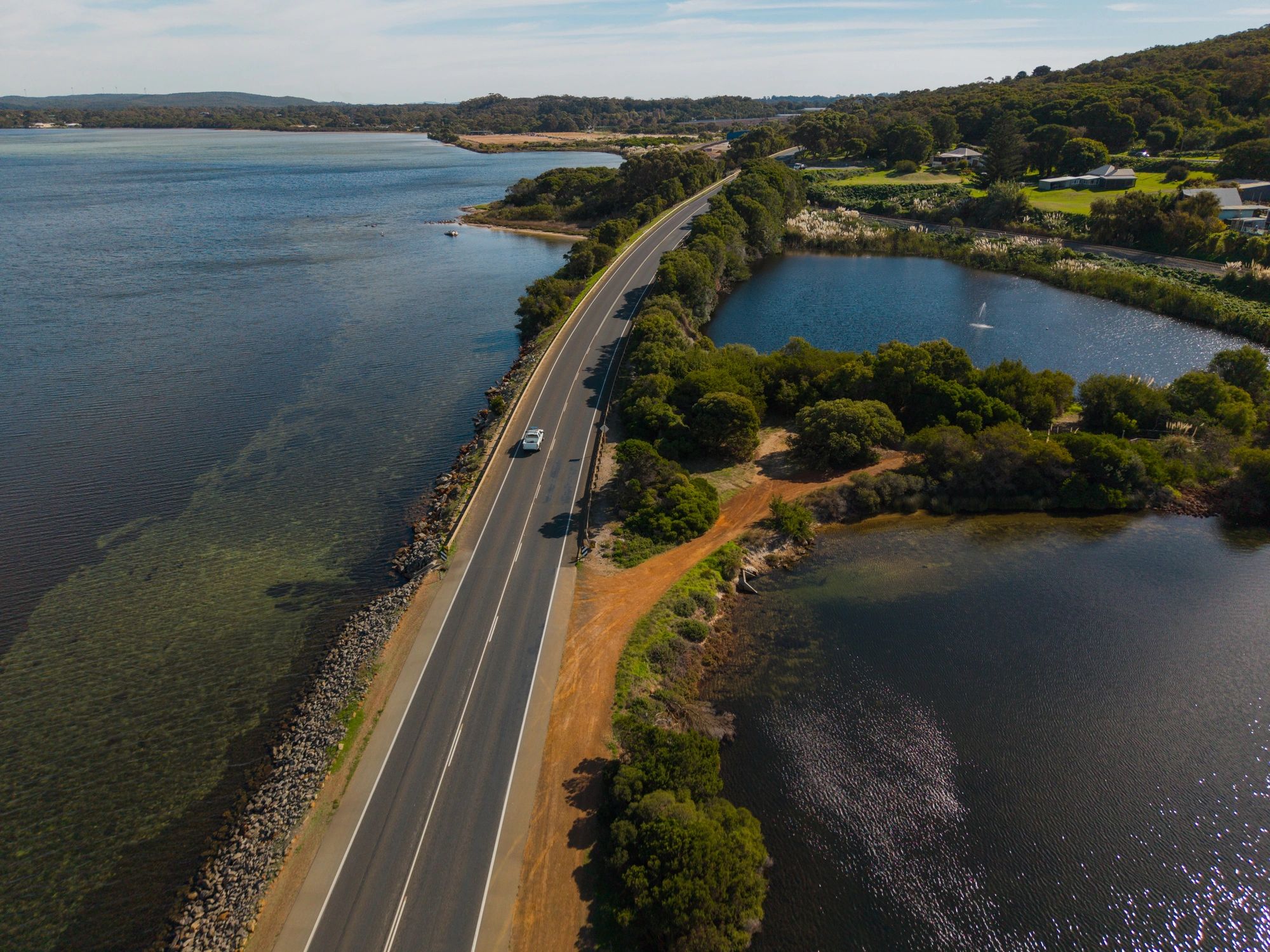 Editorial coastal road scene with a luxury car tracing the Brazilian shoreline